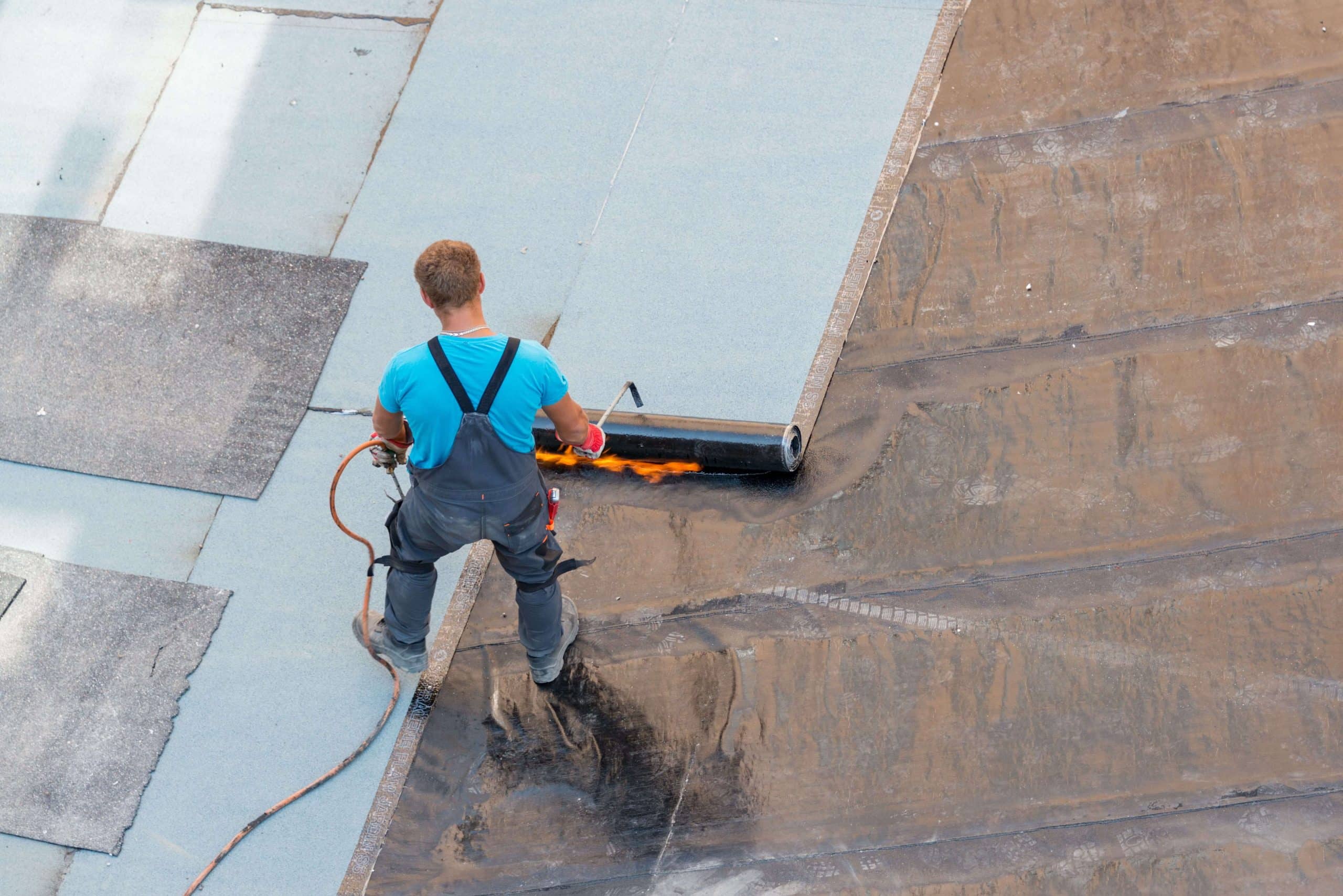 Roofing contractor repairing a flat roof.
